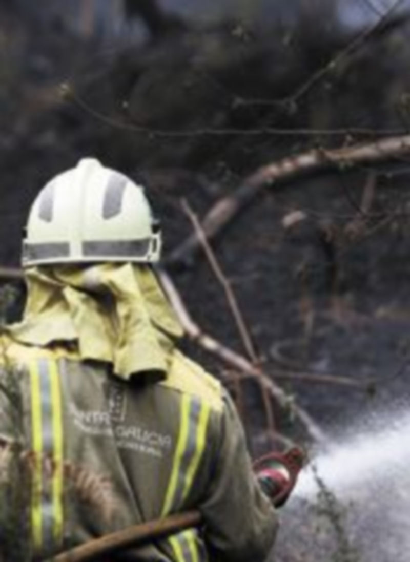 Un bombero intenta sofocar el fuego en las Fragas do Eume. / Reuters