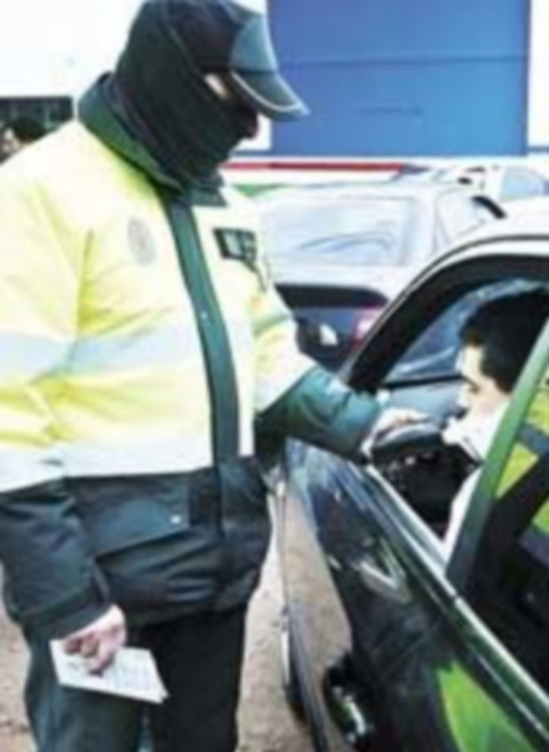 Un guardia civil hace la prueba sobre drogas a un joven conductor. / Valdivielso