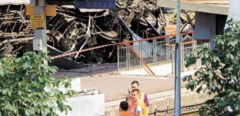 Unos operarios contemplan el estado del ferrocarril siniestrado