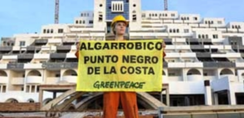 Una activista de Greenpeace frente al polémico hotel situado en la costa almeriense de Carboneras