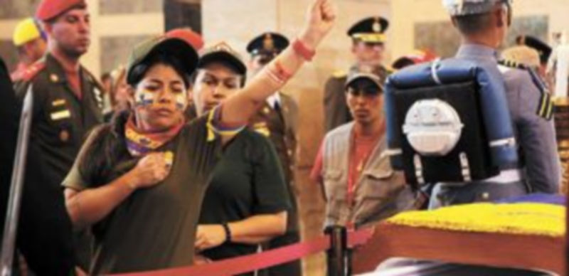 Una mujer realiza un saludo revolucionario ante el féretro del difunto presidente. / Reuters