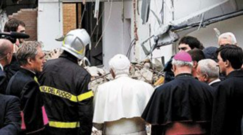 Benedicto XVI habla con un bombero durante su visita a L’Aquila. / A. DI MEO (efe)