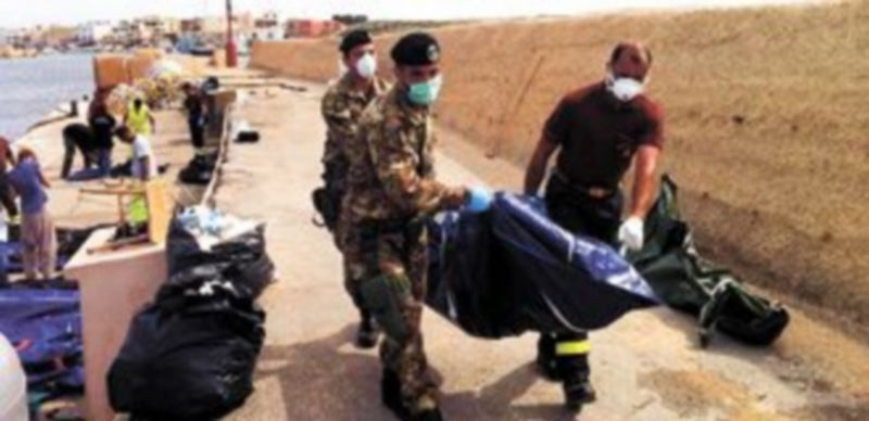 Miembros de la Armada italiana trasladan el cuerpo de uno de los fallecidos en el Mar Mediterráneo. / Reuters