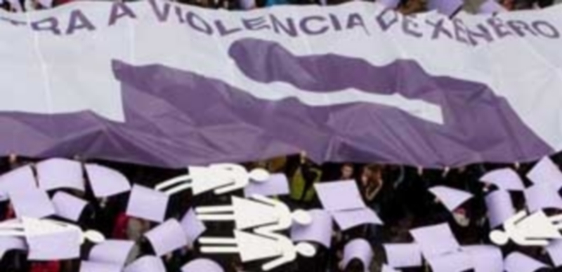Un amplio número de personas se manifiestan con una gran pancarta durante un emotivo acto contra la violencia de género en España. / Efe