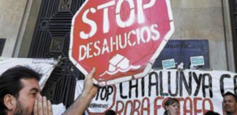 Un activista sostiene una pancarta como protesta de los desahucios. / A. Gea (Reuters)
