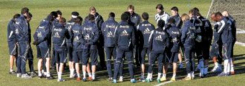 La plantilla ‘merengue’ atiende las explicaciones de Manuel Pellegrini sobre el césped de Valdebebas. / Efe