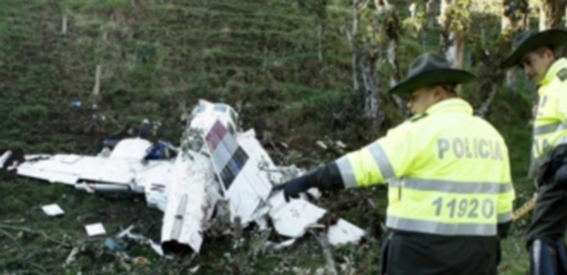 Integrantes de la policía colombiana observan el aparato siniestrado. / EFE