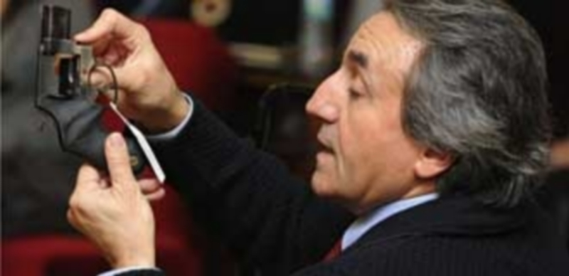 Un agente de la Policía Nacional mostrando una de las pruebas del crimen. / Efe