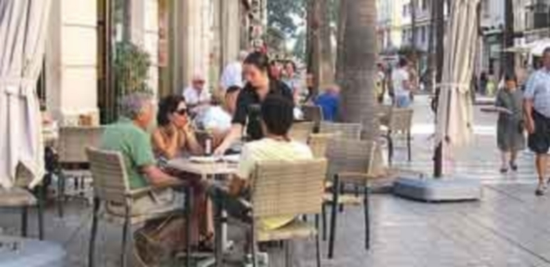 Una camarera atiende a varios clientes en una terraza. / E.P.