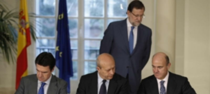 Mariano Rajoy observa la firma de José Manuel Soria(iz)