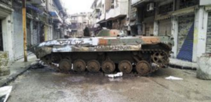 Un vehículo blindado del Ejército de Damasco obstaculiza el paso en una de las principales calles de Homs. / Reuters.