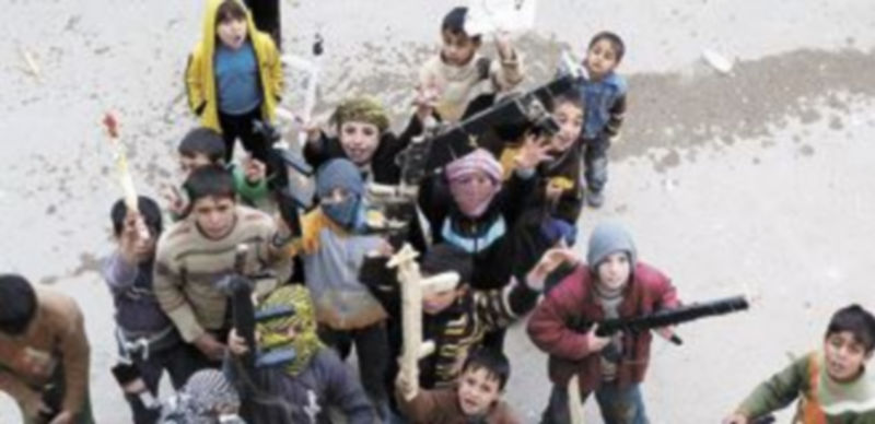 Unos niños armados posan ante la cámara en la ciudad de Homs. / Reuters.
