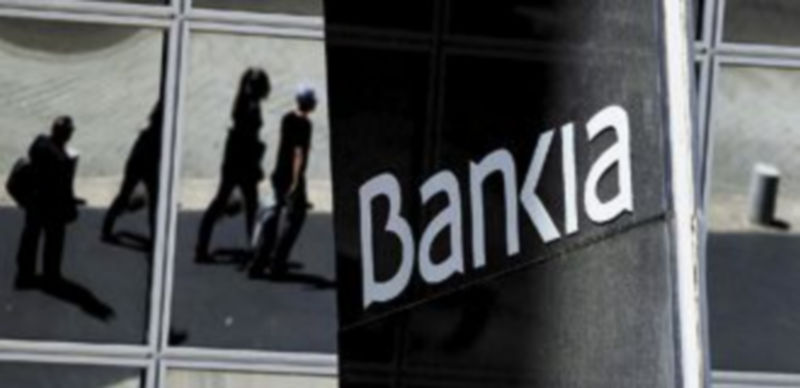 Un grupo de ciudadanos pasa por delante de la sede madrileña de Bankia. / Reuters.