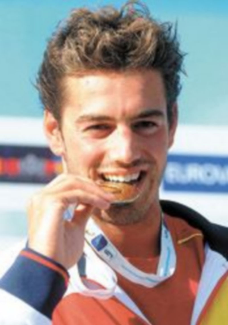 El nadador español Rafael Muñoz muerde su medalla de oro. / EFE