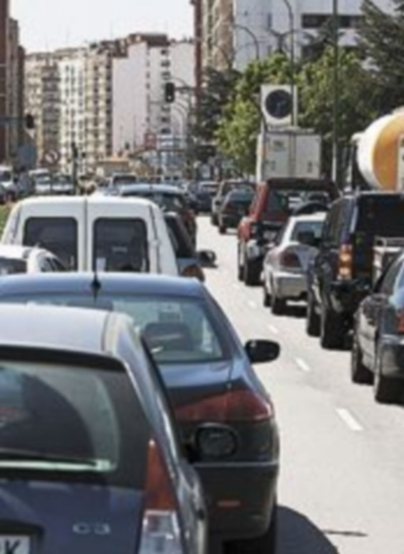 Varios coches en una avenida.