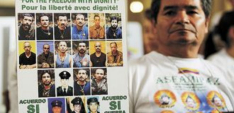 Un familiar de unos de los retenidos muestra un cartel durante la espera. / Reuters