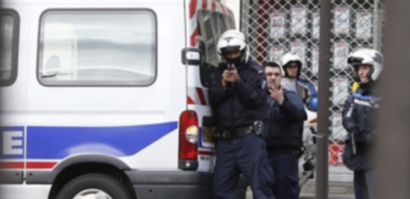 Un policía francés apunta con su pistola durante un control rutinario cerca de una mezquita