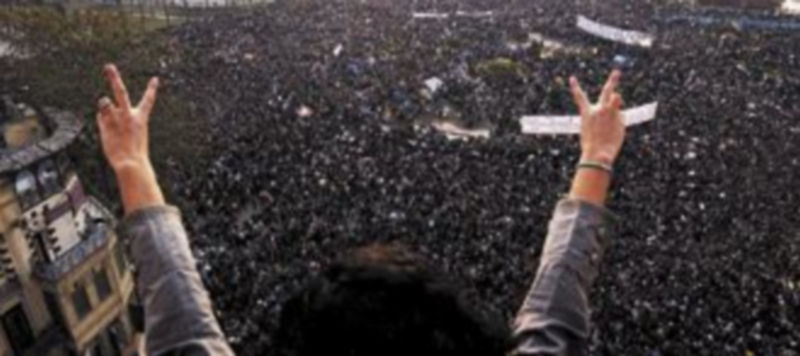 Una mujer hace el signo de la victoria delante de miles de personas que participaron en la ‘marcha del millón’ que tuvo lugar ayer en El Cairo. / Efe.