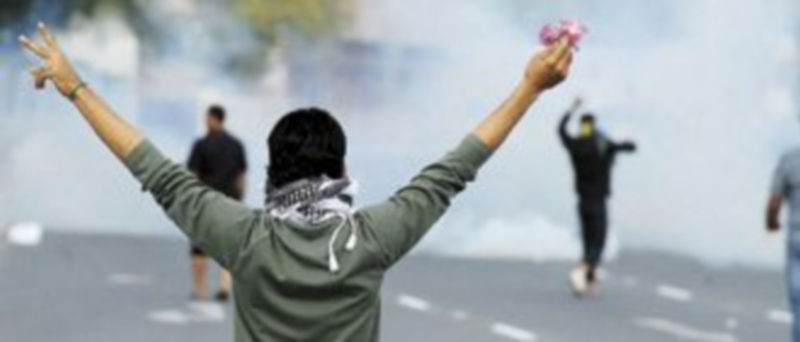 Un manifestante sostiene una flor durante los enfrentamientos con las fuerzas policiales cerca del Centro Médico Salmaniya