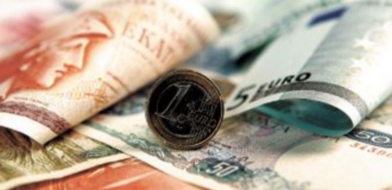 Billetes griegos aparecen junto a una moneda de un euro de la región comunitaria / Reuters