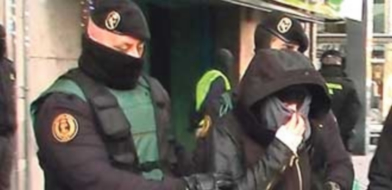 La Guardia Civil conduce a una de las detenidas por presunta pertenencia a una red de captación yihadista. / Efe