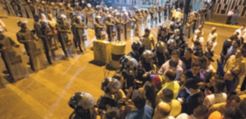 La Policía Nacional Bolivariana custodia el Servicio Bolivariano de Inteligencia frente a los opositores congregados al darse a conocer el arresto. / Efe