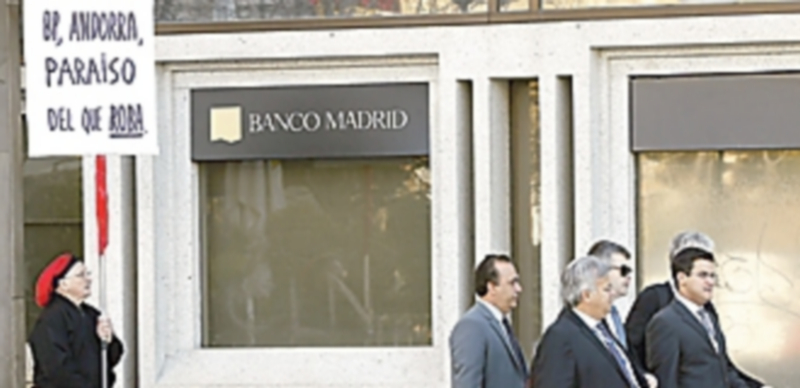 Un hombre protesta ante la sede del Banco Madrid