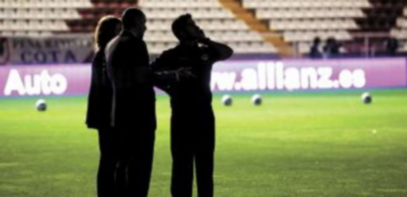 Miembros de los cuerpos técnicos de ambos equipos comprueban la escasa visibilidad en el Teresa Rivero debido al problema con la luz eléctrica. / Reuters