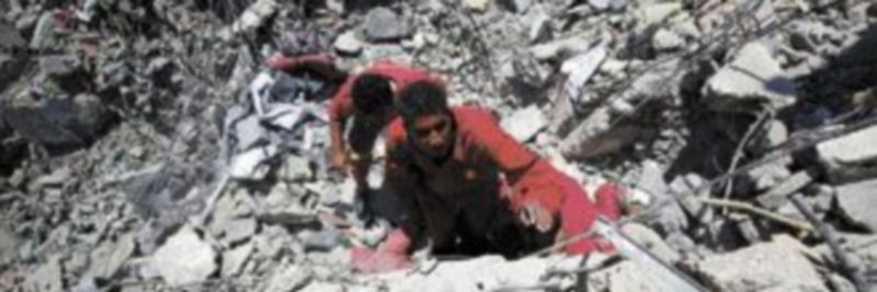 Miembros de los equipos de rescate buscan supervivientes entre los escombros de un complejo residencial bombardeado por la OTAN. / REUTERS