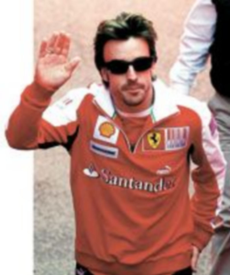 Alonso saluda a los aficionados a su llegada al trazado levantino. / Reuters