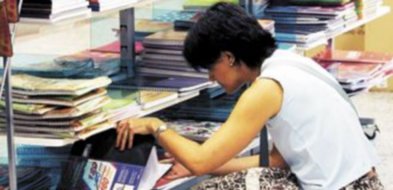 Una madre compra libros de texto y material escolar en un establecimiento comercial. / Efe