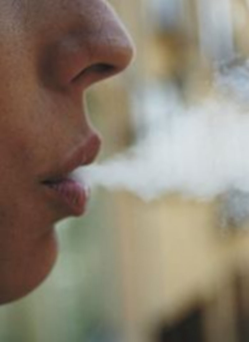 Un joven expulsa humo de tabaco.