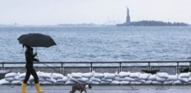Una mujer pasea bajo la lluvia por la gran metrópoli