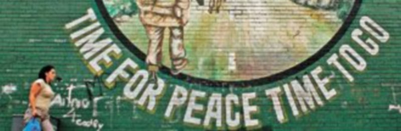 Una mujer pasa por delante de un mural republicano irlandés en Belfast