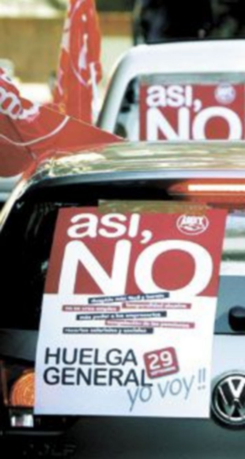 Varios coches lucen carteles y banderas de llamamiento al paro en Madrid. / EFE