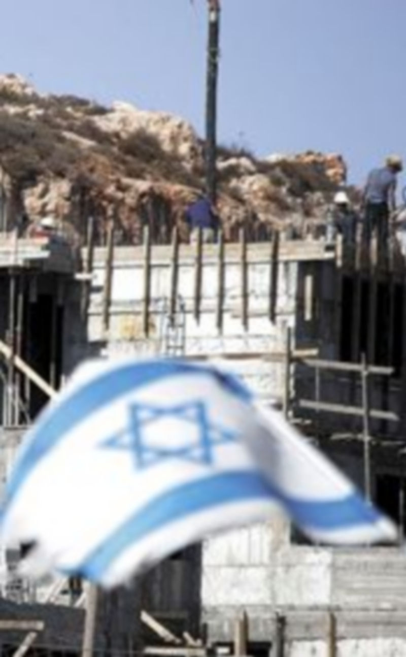 Una mujer palestina camina por uno de los asentamientos cisjordanos hacia un puesto de control. /  Efe