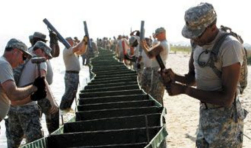 Militares de la Guardia Nacional de EEUU colocan una barrera contra la marea negra en una playa de Luisiana. /REUTERS