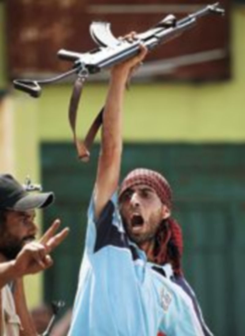 Un miliciano rebelde celebra la conquista de la televisión estatal libia en Trípoli. / Reuters