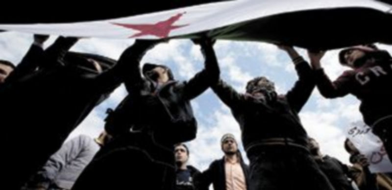 Activistas sirios ondean la bandera de su país para reclamar el fin de la ofensiva del Ejército de Bachar al Asad sobre Homs. / Reuters.