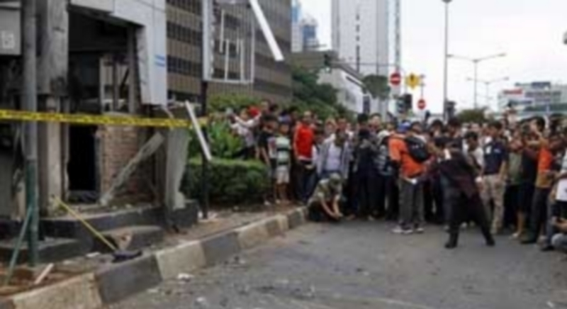 Una multitud rodea un charco de sangre marcado con tiza en el lugar donde se produjo una explosión cerca de un centro comercial en la capital de Indonesia. / EFE