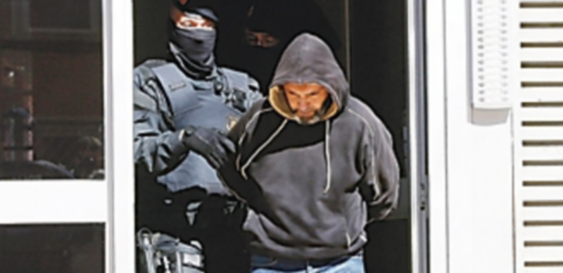 Mossos d'Esquadra custodian a una de las once personas que fueron detenidas en una operación contra el terrorismo. / Efe