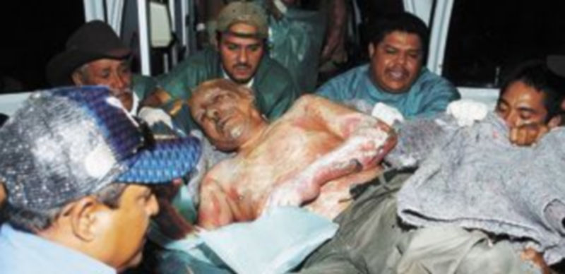 Miembros de los Bomberos evacúan a uno de los supervivientes del incendio en la prisión de Comayagua. / Reuters.