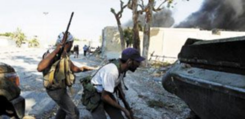 Dos milicianos insurgentes toman posición para asaltar el complejo de Bab al Aiziziya