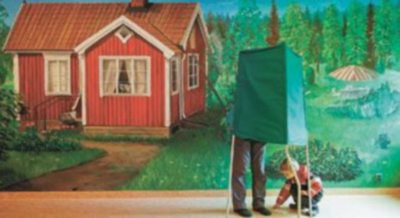 Un hombre acompañado por un niño deposita su voto en un colegio electoral de Estocolmo. / Reuters