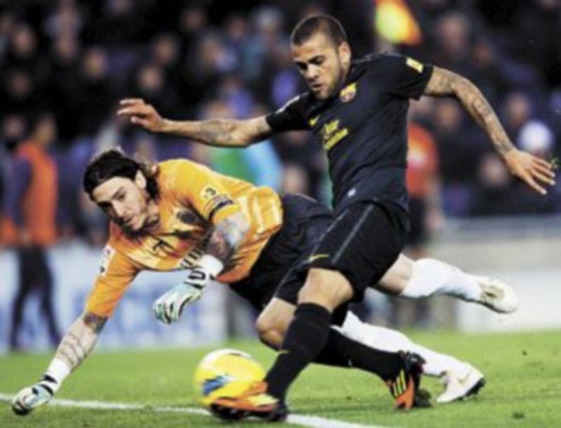 El brasileño Dani Alves intenta superar al cancerbero del Espanyol