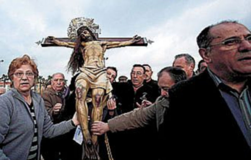 Los fieles tocan la figura del Santísimo Cristo del Salvador durante la Semana Santa Marinera de Valencia. /EFE