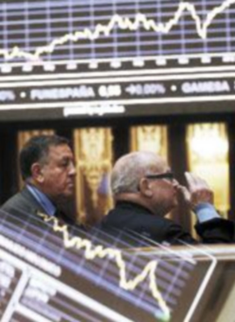 Dos inversores observan los índices de la Bolsa de Madrid. / Reuters