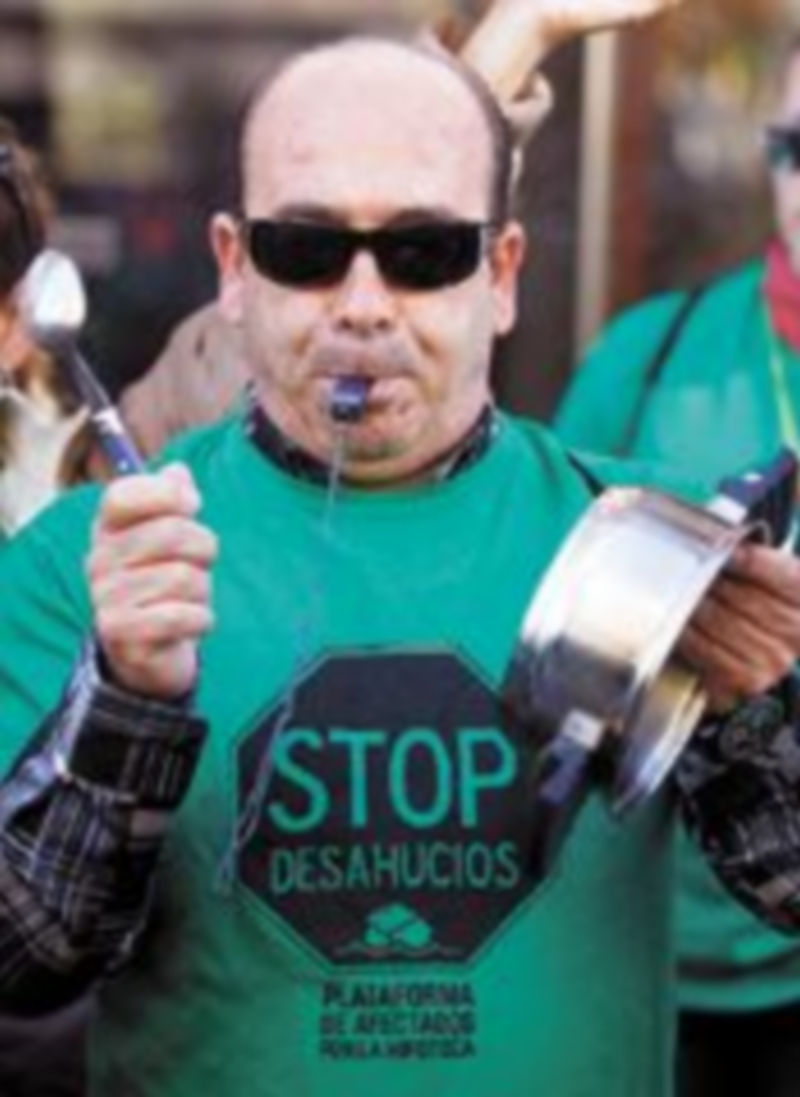 Un hombre se manifiesta en contra de los desalojos. / Reuters