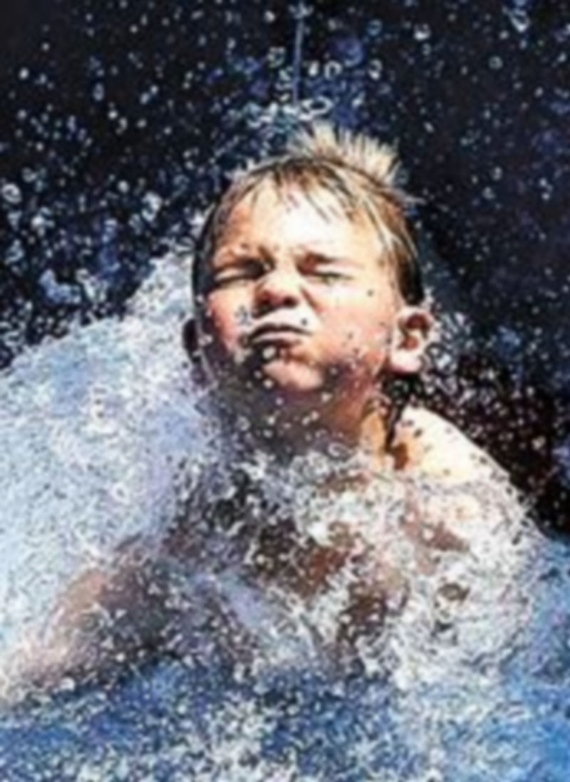 Un niño se refresca en el agua.