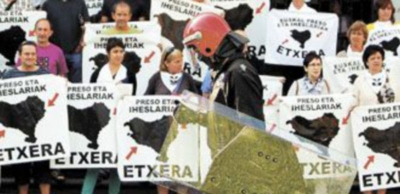 Un’ ertzaina’ pasa ante los participantes en una concentración de apoyo a los presos de ETA que tuvo lugar el pasado mes de mayo frente a la basílica de Loyola. / Efe